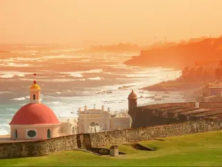 Old San Juan in Puerto Rico, ocean view with buildings in red tone during sunset
