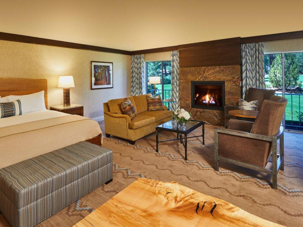 Rustic decor, with bed, lounge area and cozy fire, at Fireplace Suite within Little America Hotel, Flagstaff