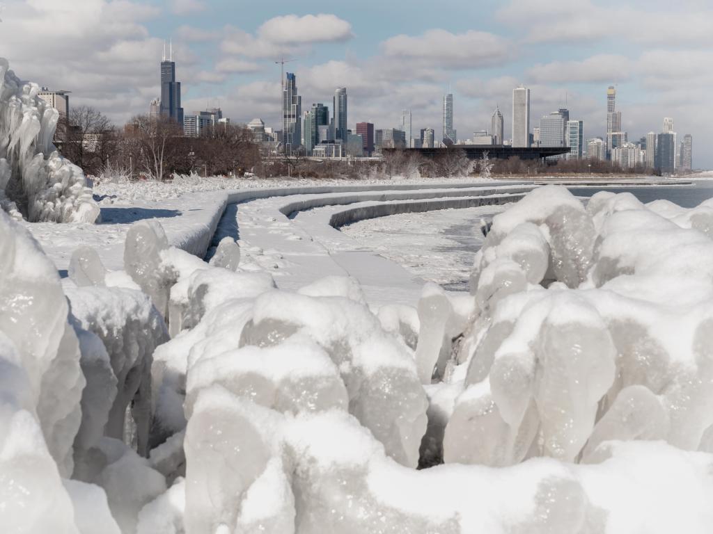 Icy formations and snow on the ground with the Chicago skyline in the background