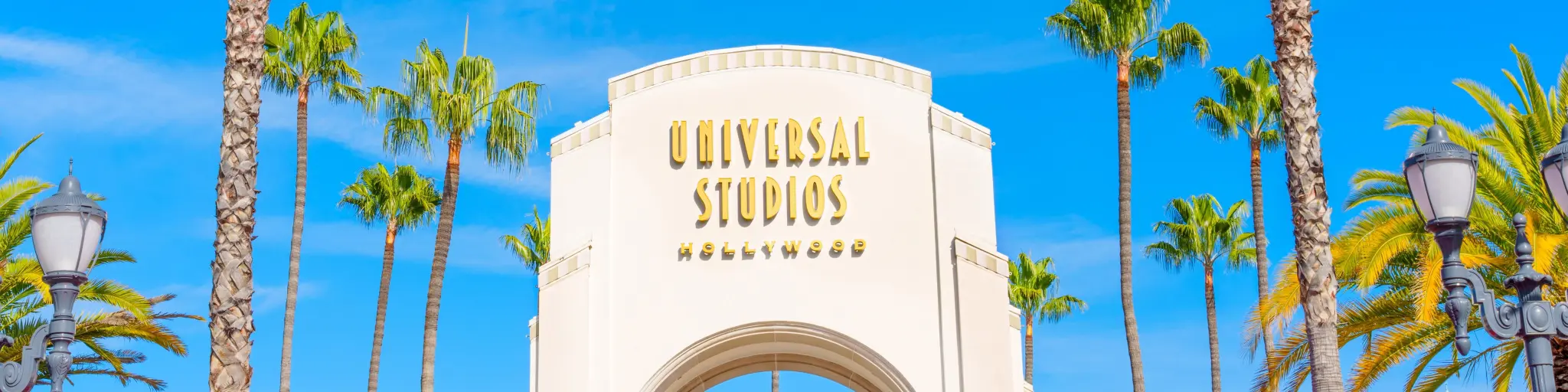 Main entrance of Universal Studios LA with palm trees and blue sky