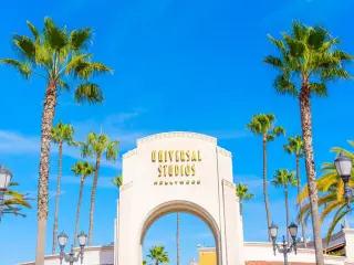 Main entrance of Universal Studios LA with palm trees and blue sky