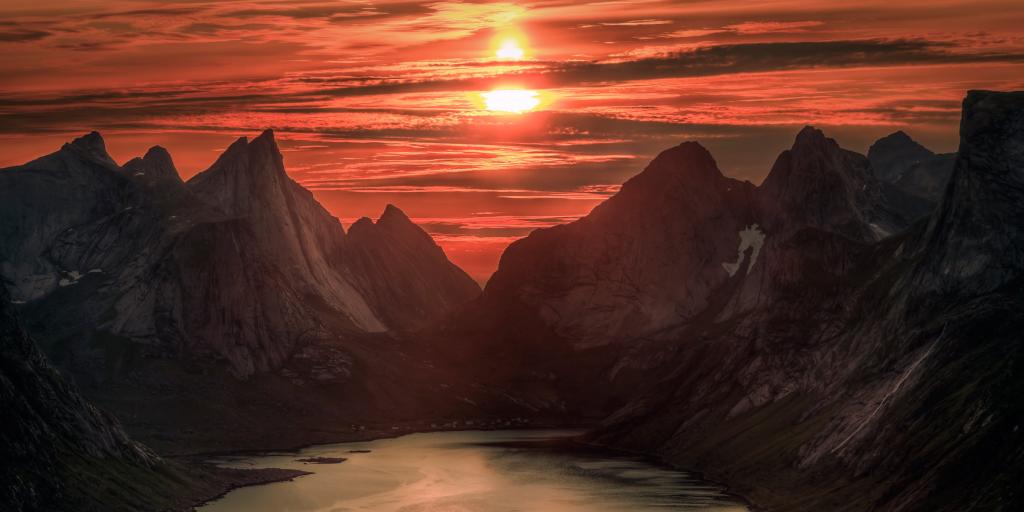 Orange skies caused by midnight sun over Reinebringen mountain, Norway, in summer