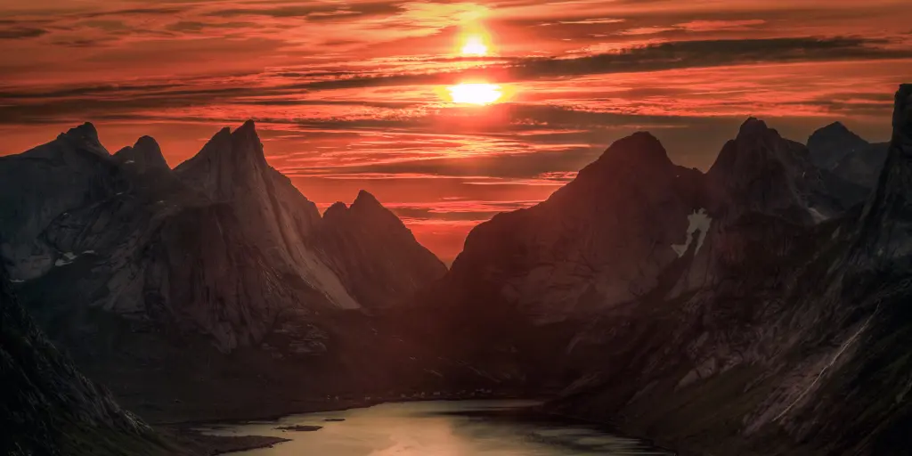 Orange skies caused by midnight sun over Reinebringen mountain, Norway, in summer