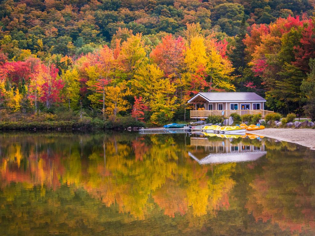 Boathouse surrounded by autumn trees, reflecting in Echo Lake, in Franconia Notch State Park, New Hampshire