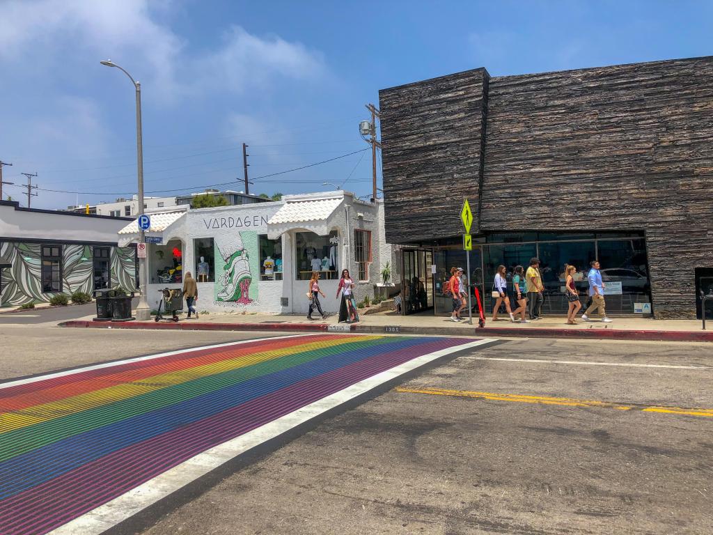 Rainbow colored pedestrian crossing with restaurants lining the road in Los Angeles