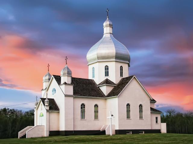 White exterior of a Ukrainian Catholic Church during sunset