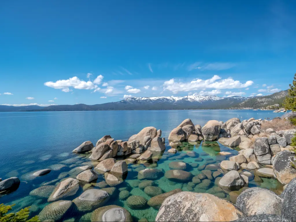 Lake Tahoe in a Snowy Winter with a blue sky and mountains in the distance.