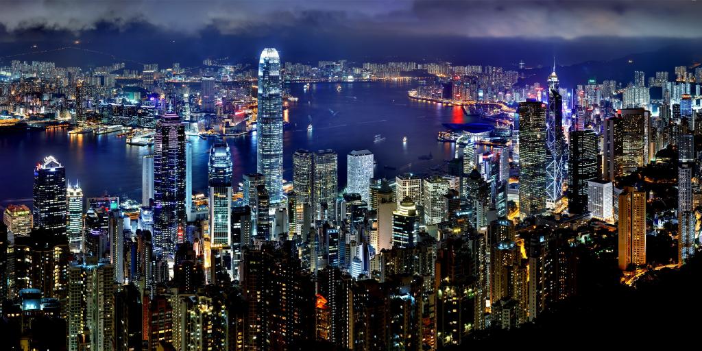 The Hong Kong skyline lit up at night with the harbour in the middle