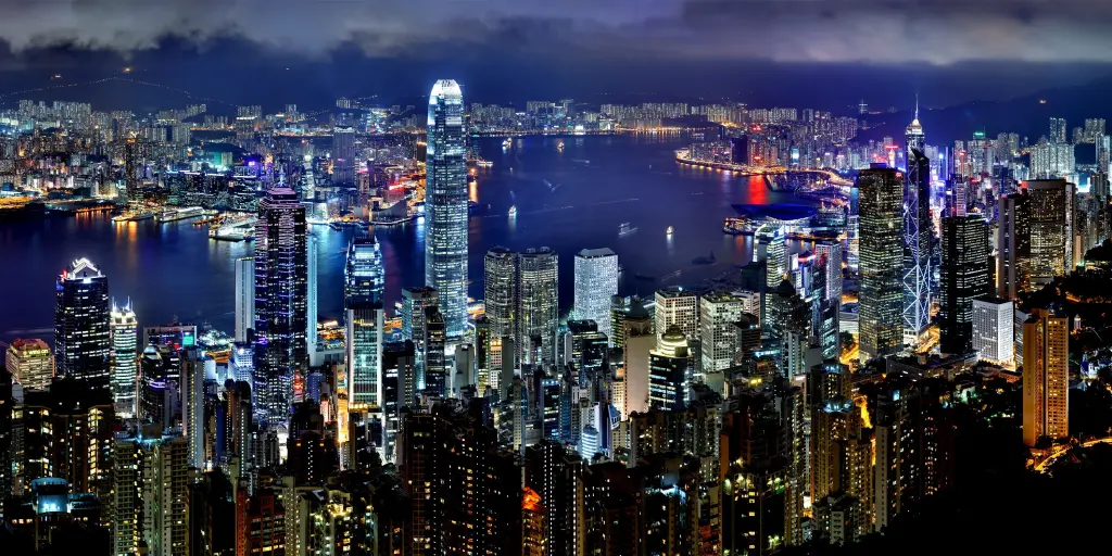 The Hong Kong skyline lit up at night with the harbour in the middle