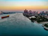 Aerial shot of Detroit Riverfront at dusk, with a large ship passing by