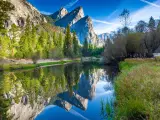 Early morning at Yosemite Valley, view of the Three Brothers and their silhouette is mirrored on Merced River