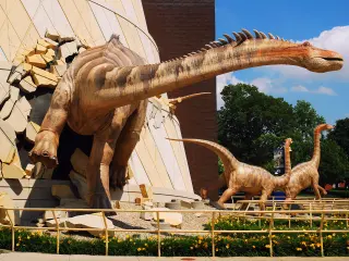A dinosaur "breaking out" of the museum, with other sculptures "running off" in the background