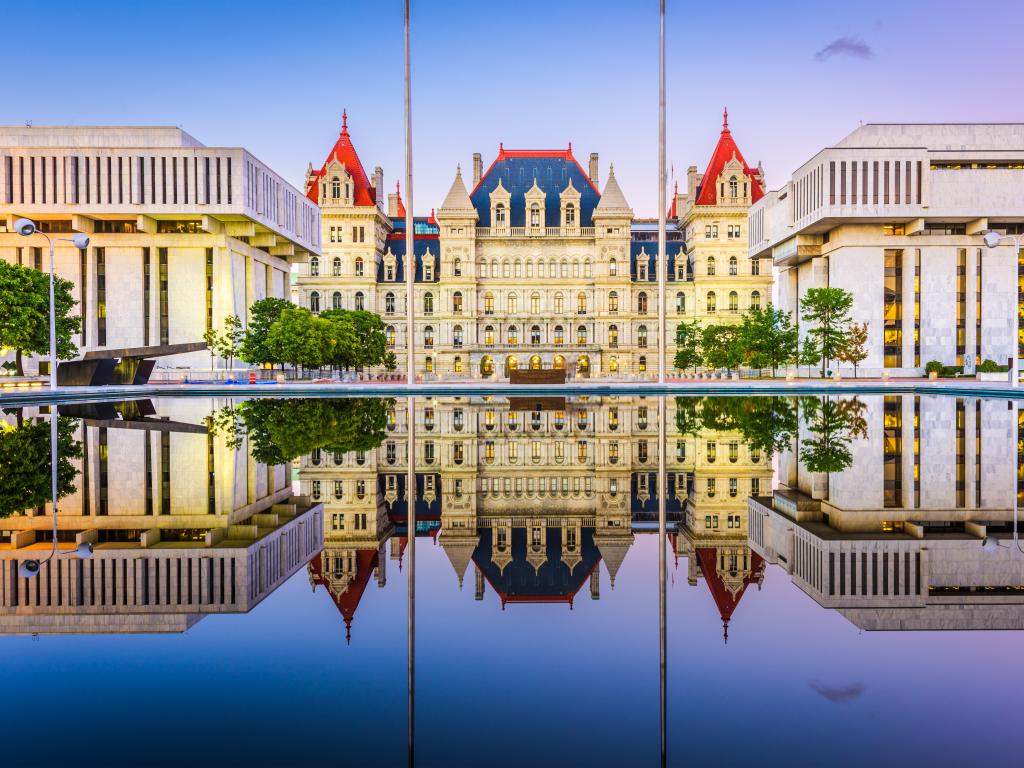 Albany, New York, USA at the New York State Capitol reflected in the water in the foreground and taken just after sunset.