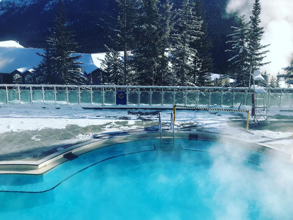 Turquoise blue waters of natural hot springs pool in winter, snow in the background