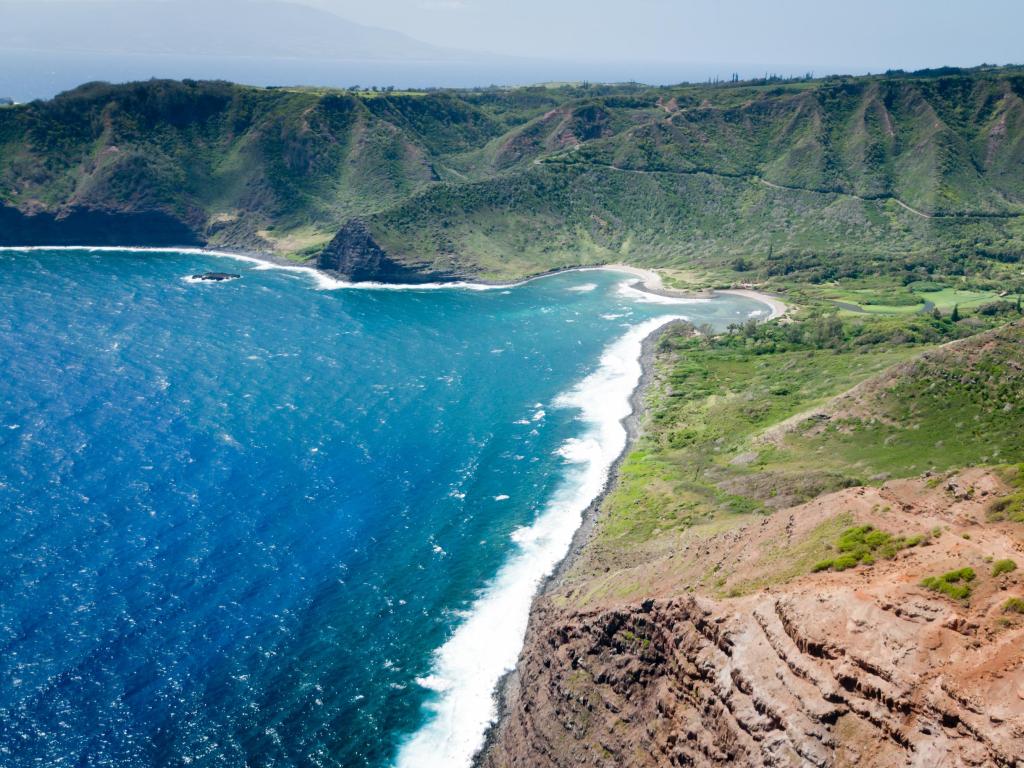 Aerial shot of the rugged Molokai island coast, Hawaii, with waves gently lapping the shoreline