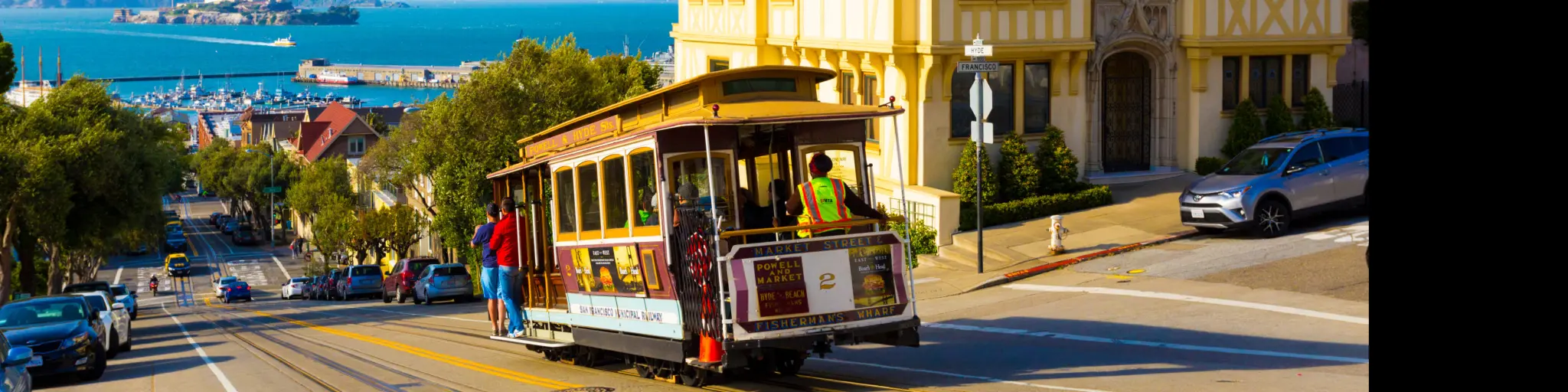 San Francisco cable car tram going downhill with Alcatraz in the background