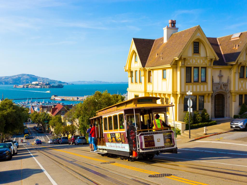 San Francisco cable car tram going downhill with Alcatraz in the background
