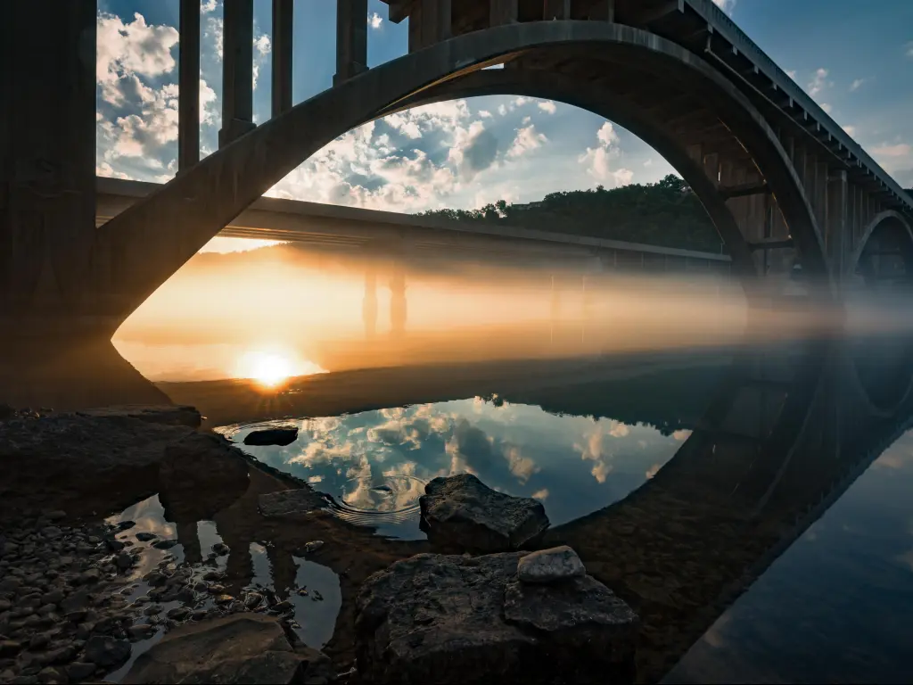 A foggy sunrise on Lake Tanycomo, Branson, Missouri, USA with a bridge in the foreground. 