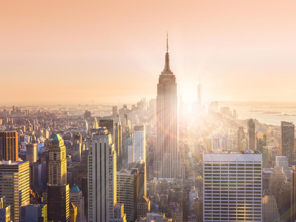 New York City, USA with the Manhattan downtown skyline with illuminated Empire State Building and skyscrapers at sunset. 