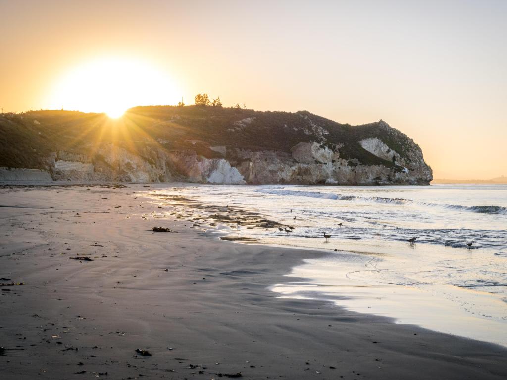 Avila Beach, California, USA sunrise behind the cliff on the ocean.