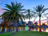 Orlando, Florida, USA downtown skyline at Eola Lake with colorful lights on the palm trees in the foreground.