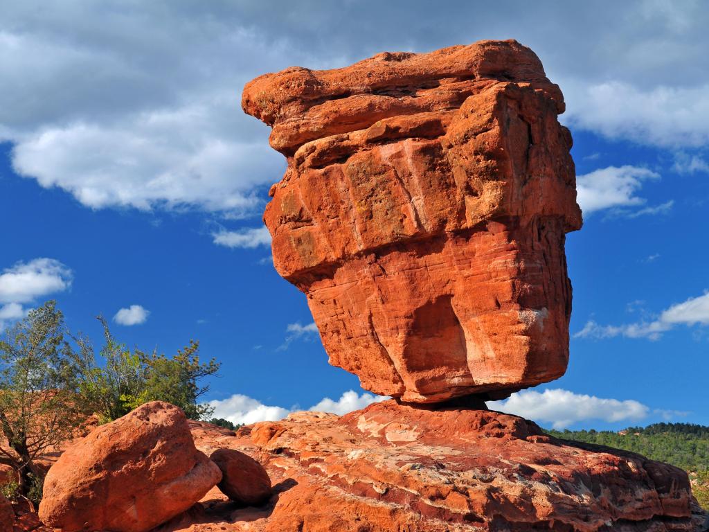A red rock boulder that looks like it might tip over at any point, sunny day