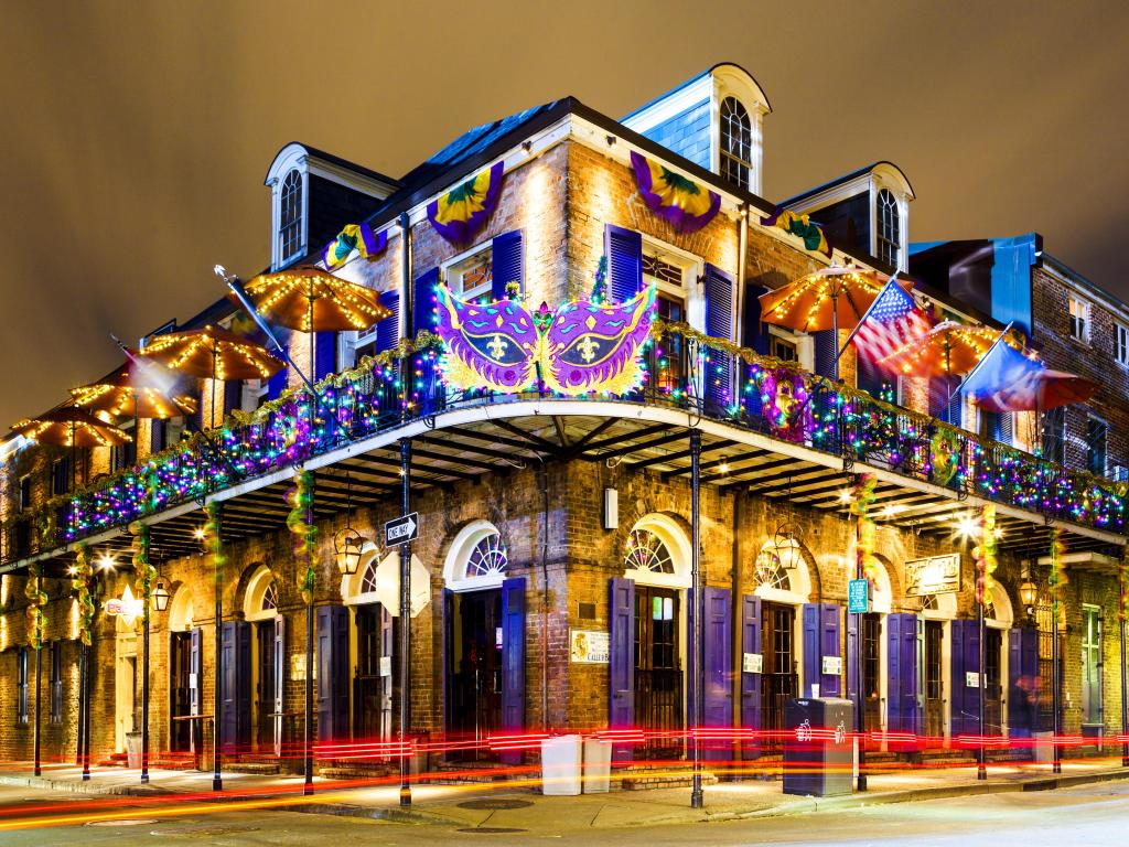 Low rise heritage building with metal balcony fittings decorated with image of carnival mask for mardi gras