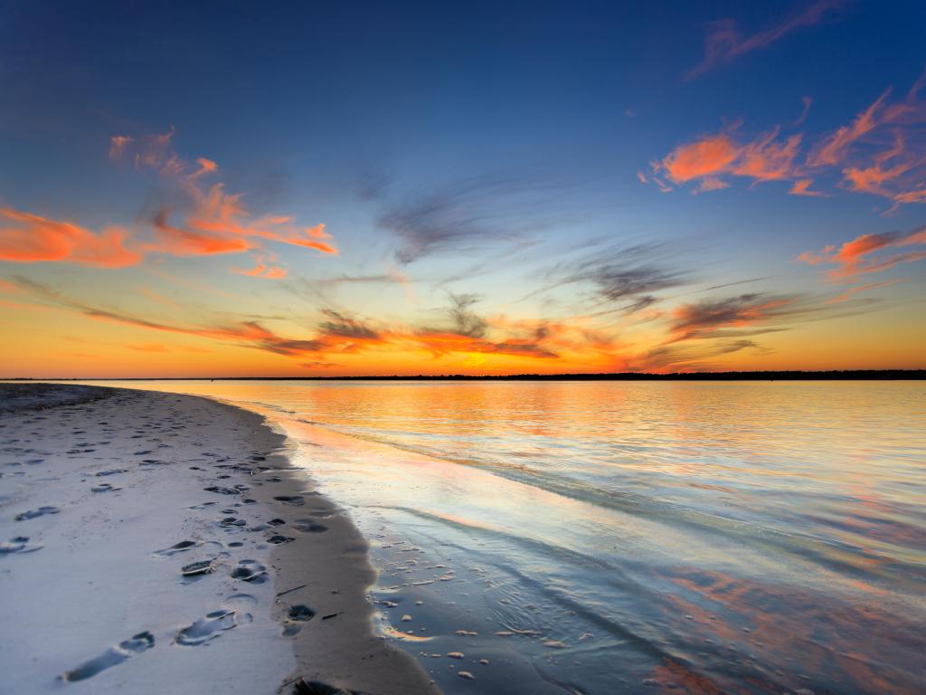 Wrightsville Beach, Wilmington, USA taken at sunset with footprints in the sand in the foreground.