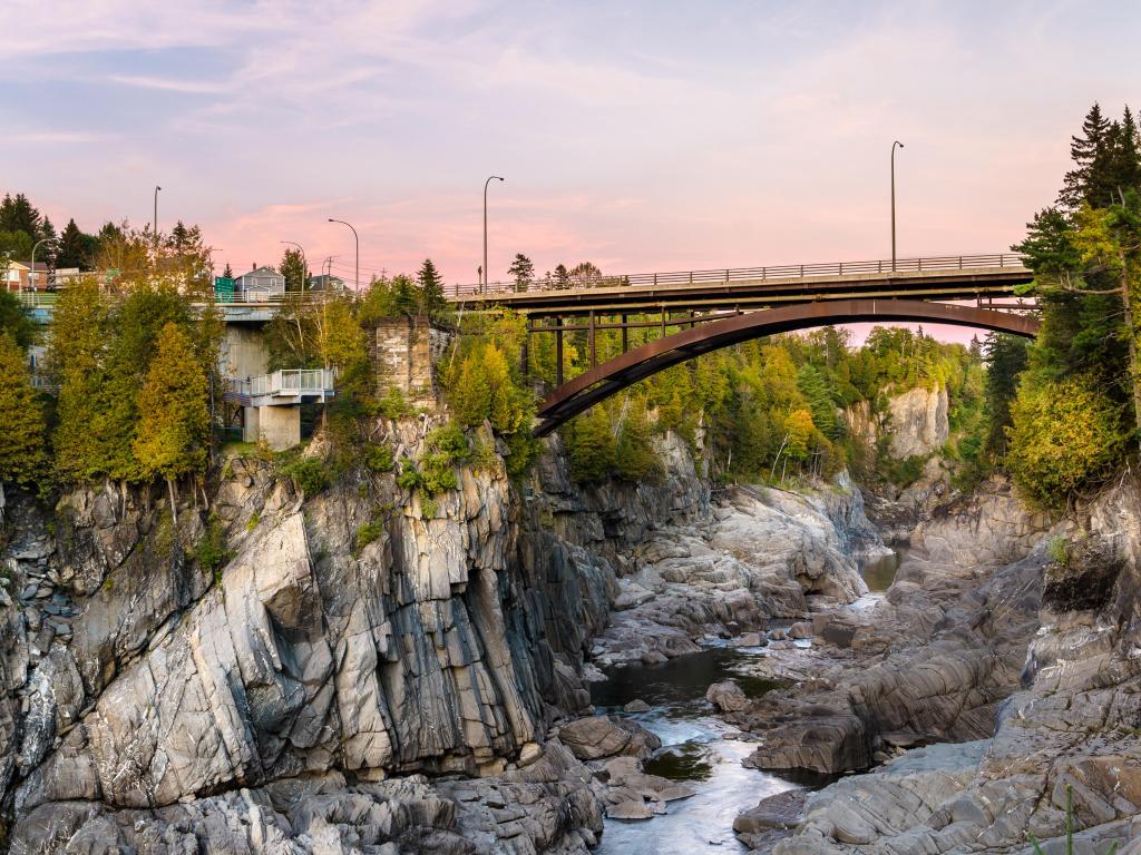 Grand Falls, New Brunswick, Canada with a road bridge over a beautiful gorge at sunset.