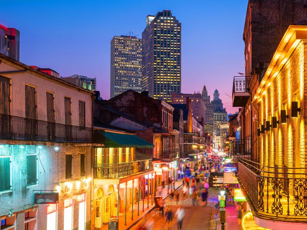 French Quarter, New Orleans, USA with the pubs and bars with neon lights taken at night and skyscrapers in the distance.