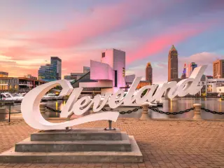 Skyline of downtown Cleveland from Voinovich Bicentennial Park during a sunset, the famous "Cleveland" sign is in focus