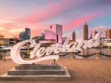 Skyline of downtown Cleveland from Voinovich Bicentennial Park during a sunset, the famous "Cleveland" sign is in focus