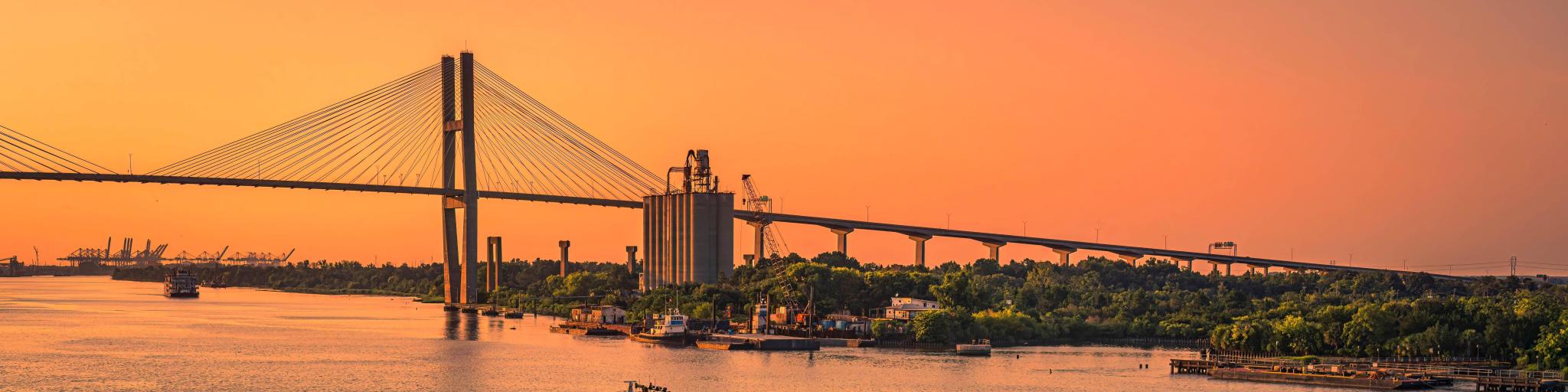 View of Talmadge Memorial Bridge and a tug boat on the river during sunset