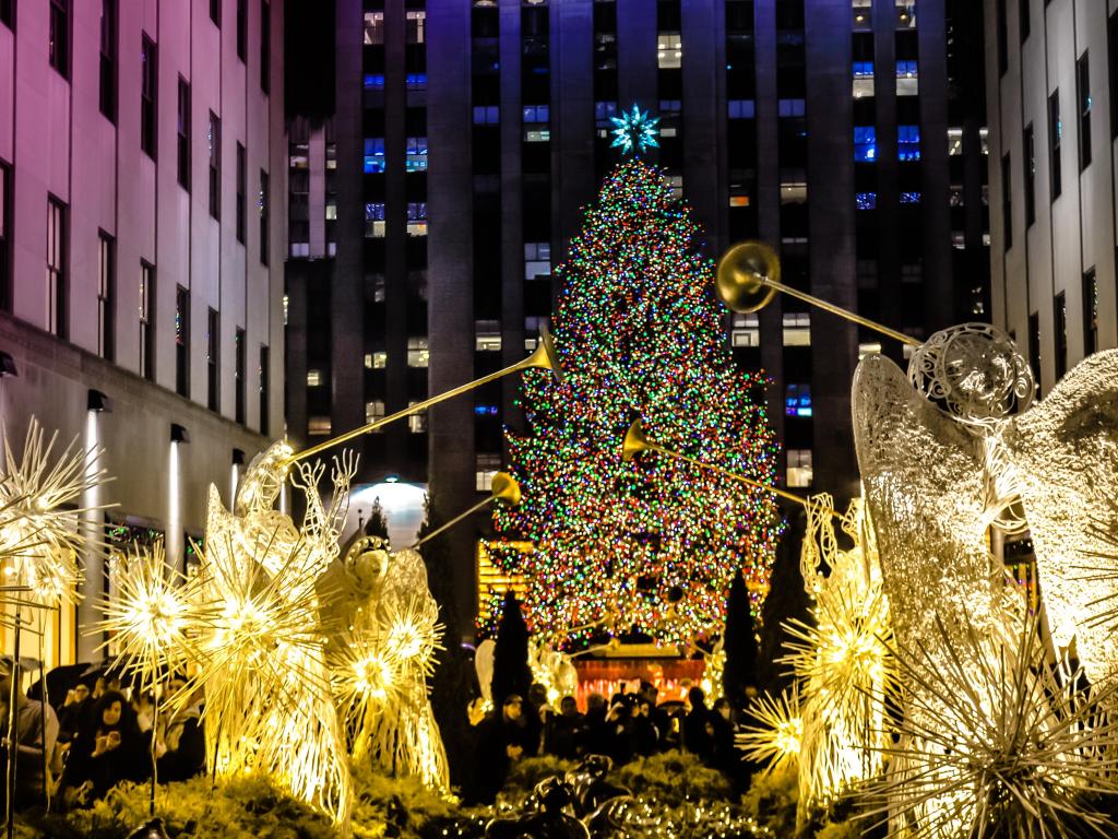 Angels with big Christmas tree with light in front of the Rockefeller center. Christmas famous decorations in Midtown, Manhattan in the New York City downtown.