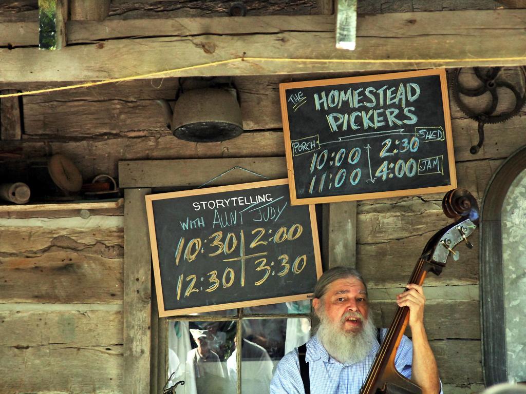 Bluegrass musician playing at a festival with antiques in the background, Branson, Missouri