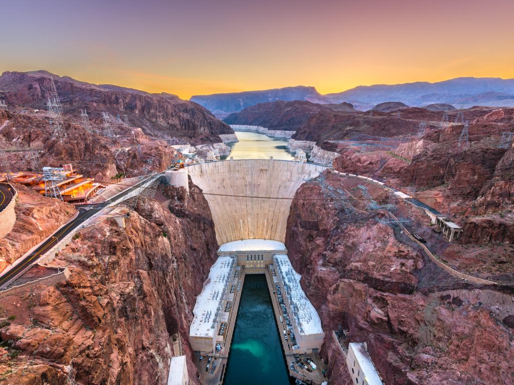 Hoover Dam on the Colorado River straddling Nevada and Arizona at dawn from above.