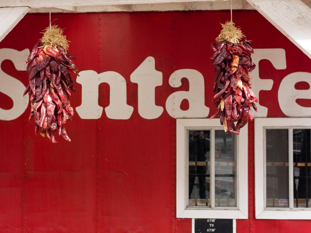 Red chilis hanging in front of an old Santa Fe railway carriage