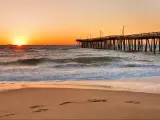 Fishing Pier at Sunrise at Virginia Beach, Virginia, USA. Virginia Beach, a coastal city in southeastern Virginia, lies where the Chesapeake Bay meets the Atlantic Ocean.