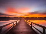 Orange sunrise at Lake Lamar Bruce near Saltillo in Mississippi, with jetty jutting out over the water