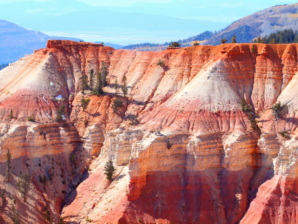 Massive orange rocky ridge with a few green pine trees