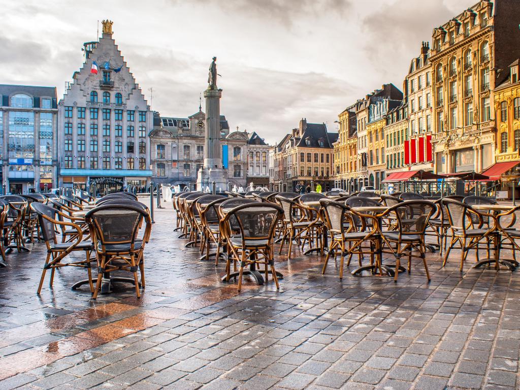 Lille, France taken at Grand Place with tables and buildings in the distance.