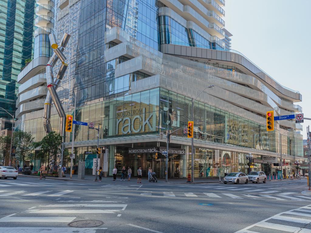 High-end shopping street with department stores and a modern sculpture to the building's side