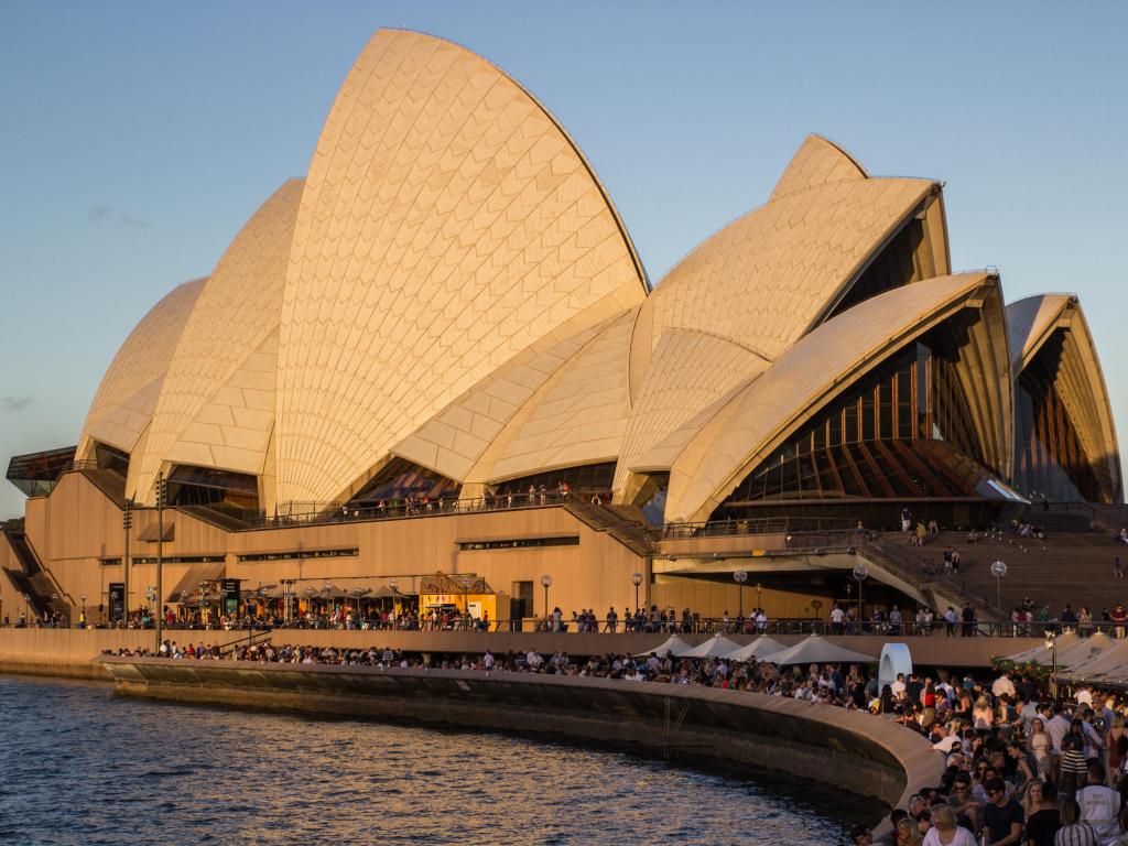  Busy Sydney Opera house during golden hour on new years eve lot of tourists and travellers on vacation and holiday enjoying the sun and architecture