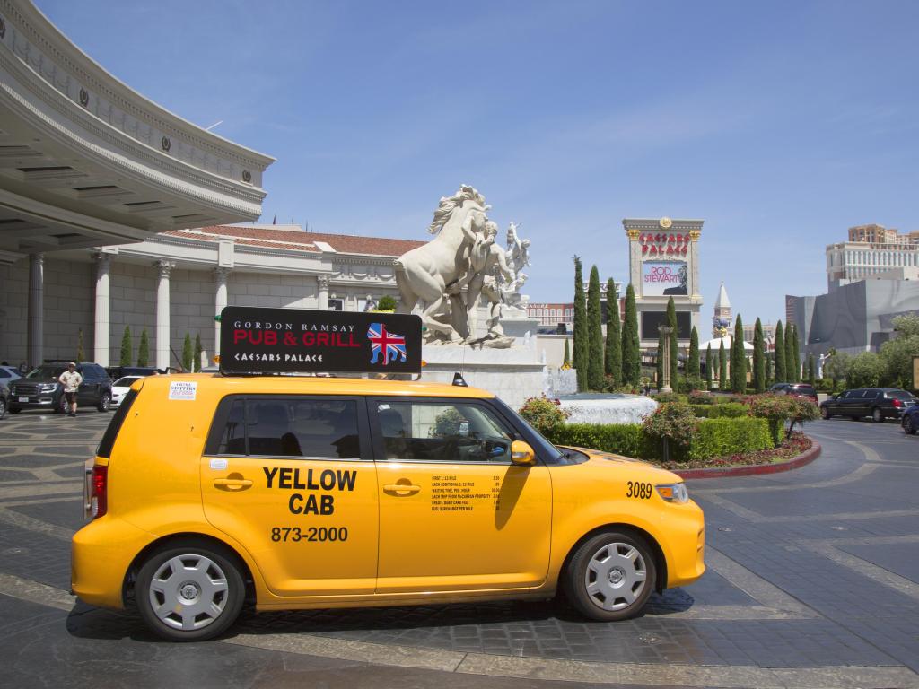 Yellow Cab pulling into the traffic in Las Vegas with the famous hotels in the background