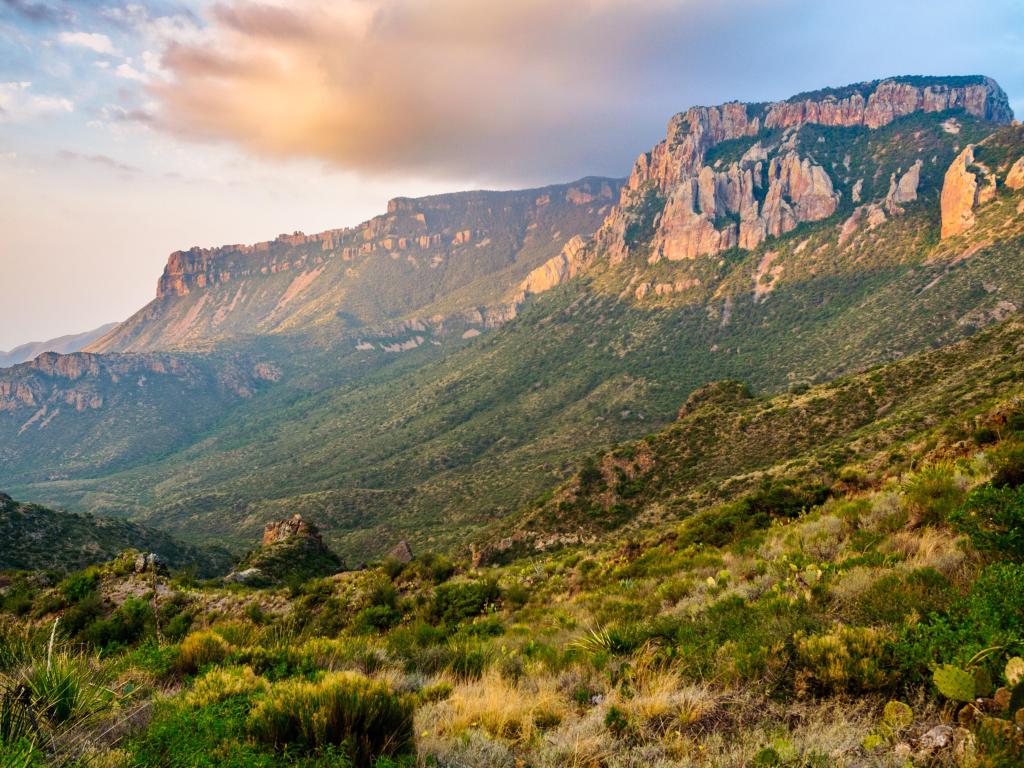 Dramatic Mountains at Big Bend National Park at dusk. There are some clouds in the sky.