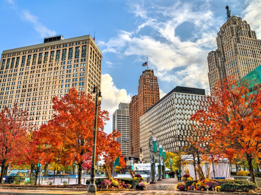 An autumnal display of red and orange hued trees surrounding historic buildings in Downtown Detroit 