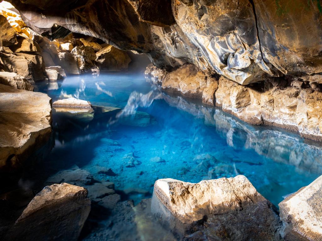 Cobalt blue waters in the cave, surrounded by dramatic rock formations