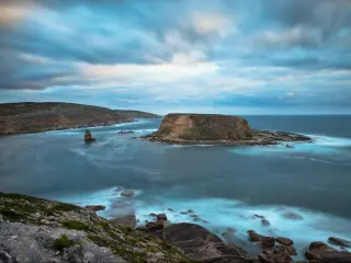 Lincoln National Park, South Australia with a view of the untouched western coastline, rocks in the foreground and in the distance surrounded by sea.