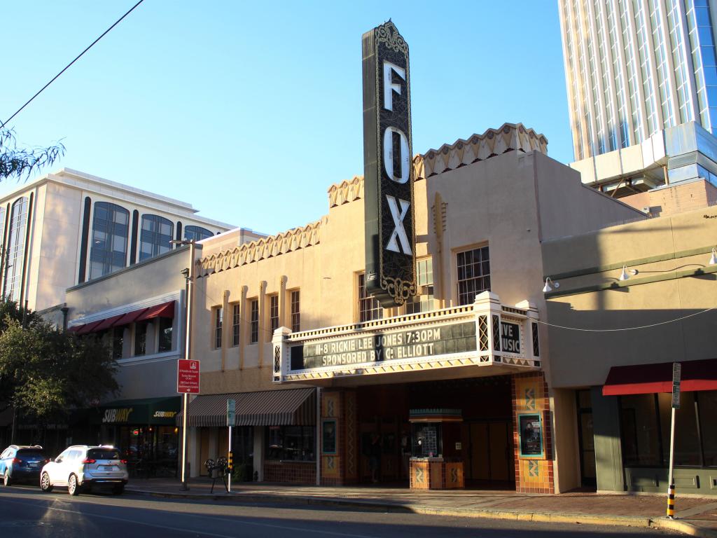 The facade of the small, old-fashioned theatre with a blue sky in the background