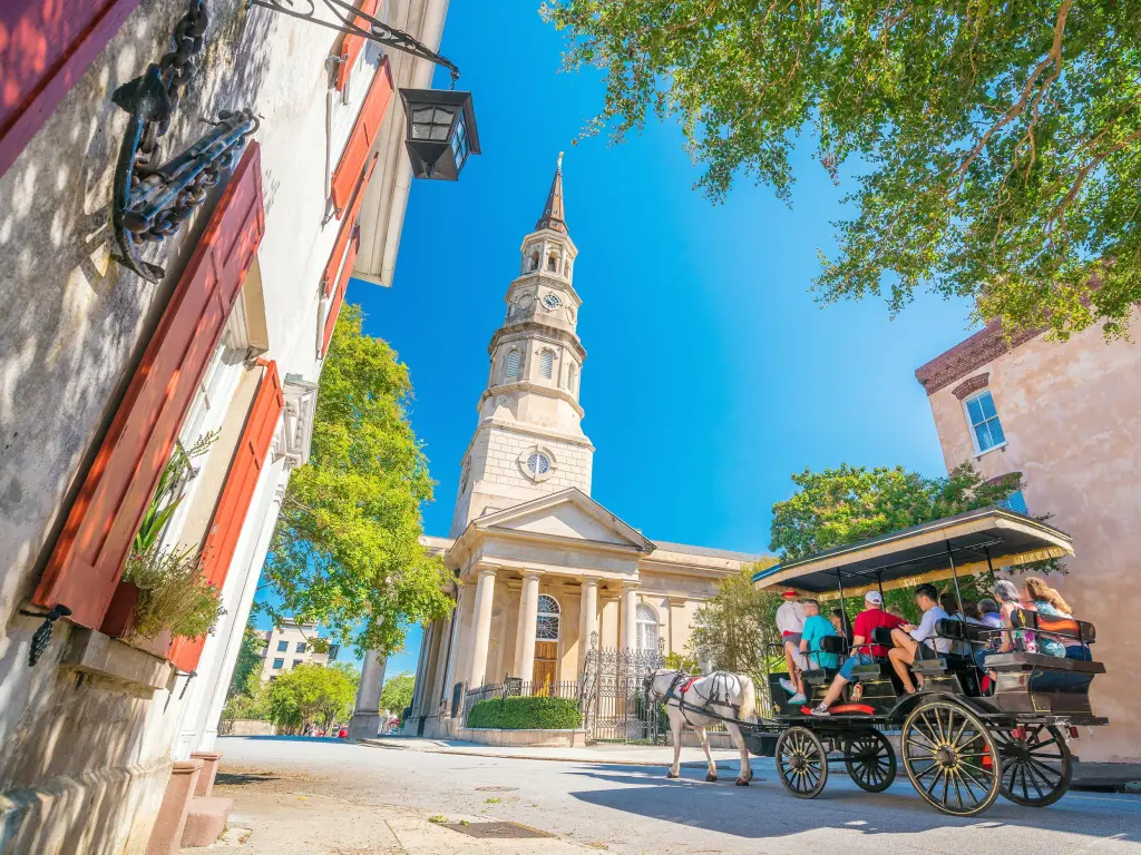 Horse drawn tourist cart travelling through streets of historical downtown area of Charleston